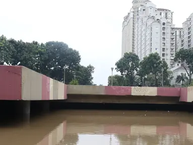Warga melihat banjir yang mengenangi underpass Kemayoran, Jakarta, Minggu (2/2/2020). Banjir kembali merendam underpass Kemayoran, Jakarta Pusat. Akibatnya, akses jalur tersebut pun terputus alias tak bisa dilalui kendaraan. (Liputan6.com/Angga Yuniar)