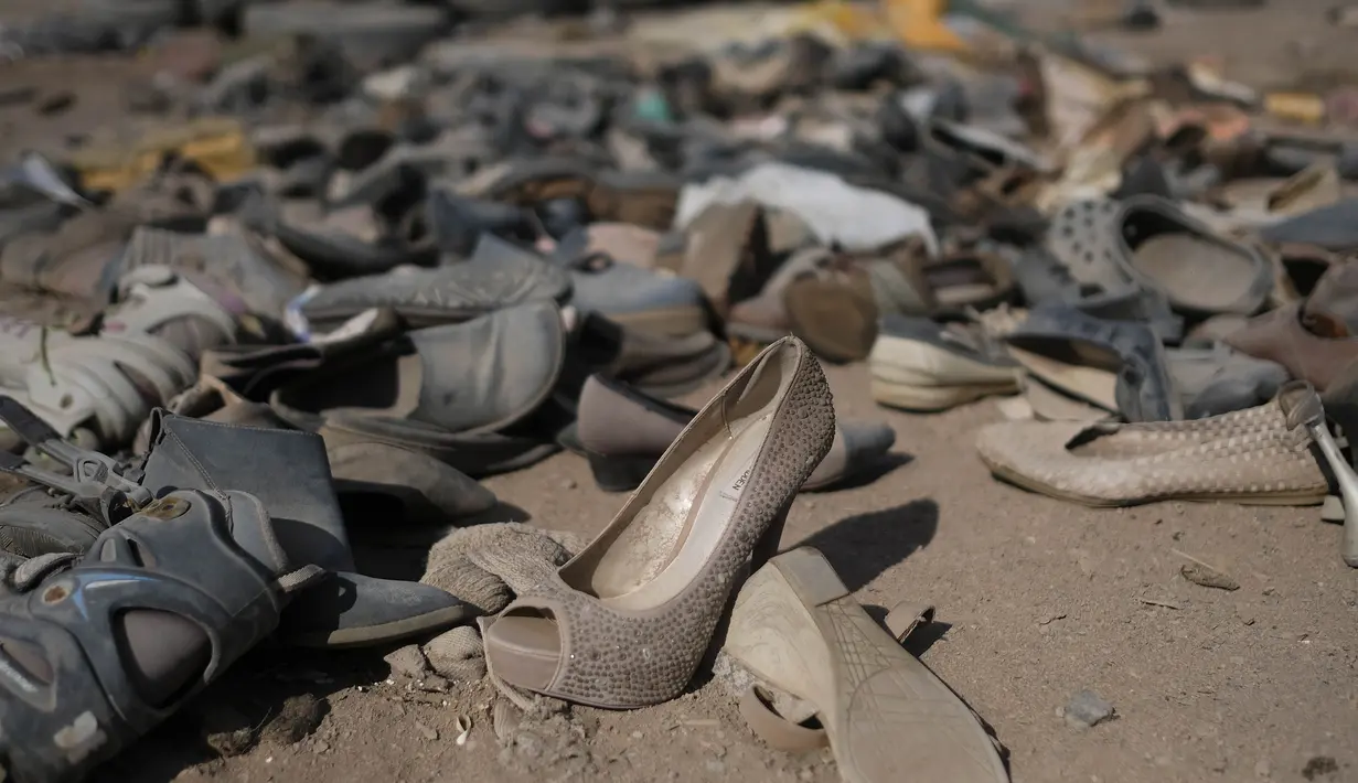 Sepatu bekas tergeletak di tengah tumpukan besar pakaian bekas yang menutupi gurun pasir di dekat lingkungan La Mula di Alto Hospicio, Chile, Senin (13/12/2021). Chile adalah importir besar pakaian bekas, dan barang-barang yang tidak terjual dibuang di sini. (AP Photo/Matias Delacroix)