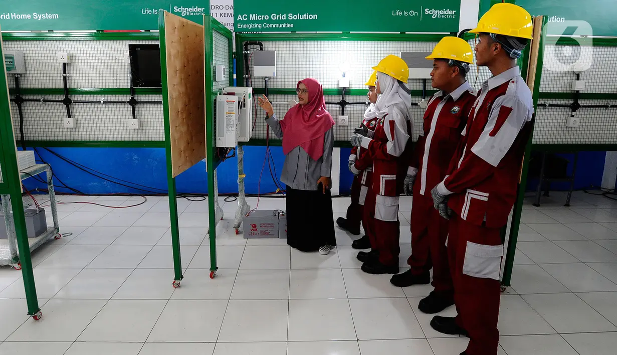 Seorang guru mengajarkan praktek perawatan solar panel kepada siswa kompetensi keahlian Teknik Energi Surya Hidro dan Angin (TESHA) di SMK Negeri 1 Kemang Bogor, Jawa Barat, Kamis (19/5/2022). Solar panel teserbut selain sebagai media pembelajaran siswa juga menghasilkan energi listrik yang digunakan untuk kebutuhan pasokan listrik di lab sekolah tersebut. (merdeka.com/Arie Basuki)