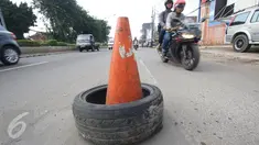 Kendaraan menghindari penanda lubang di Jalan Otista Raya, Jakarta, Rabu (22/2). Kondisi tersebut berbahaya bagi pengguna jalan, khususnya pengendara sepeda motor yang melintas saat malam hari. (Liputan6.com/Immanuel Antonius)
