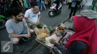 Wisatawan mancanegara membeli sate ayam di Jalan Malioboro, Yogya, Kamis (4/8). Makanan cepat saji ini banyak dijual di sepanjang Jalan Malioboro dengan harga yang terjangkau. (Liputan6.com/Boy Harjanto)