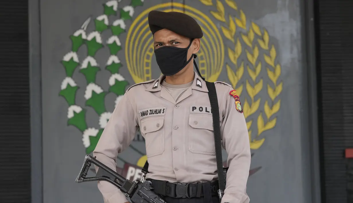Seorang petugas polisi berjaga di pintu masuk utama Lapas Kelas I Tangerang Banten,  usai kebakaran, Rabu (8/9/2021). Sebanyak 18 unit mobil pemadam kebakaran diterjunkan dalam menjinakkan si jago merah yang melahap sebagian bangunan Lapas Kelas I Tangerang. (AP Photo/Dita Alangkara)