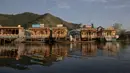 Seorang wanita membeli sayuran dari penjual di shikara atau gondola tradisional di Danau Dal, Srinagar, Kashmir, India, Rabu (22/7/2020). Danau Dal terkenal dengan airnya yang jernih dan tenang. (AP Photo/Dar Yasin)