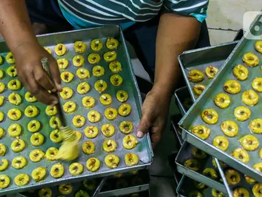 Seorang pekerja membuat kue di industri pembuatan kue kering Pusaka Kwitang, Jakarta, Kamis (30/4/2020). Kue kering yang dijual seharga Rp480 ribu per kaleng itu pada bulan Ramadan tahun ini mengalami penurunan produksi hingga 500 kaleng akibat pandemi COVID-19. (Liputan6.com/Johan Tallo)