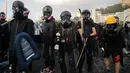 Demonstran prodemokrasi mempersenjatai diri saat bersiap di luar Chinese University, Hong Kong, Rabu (13/11/2019). Gerakan antipemerintah Hong Kong yang telah berlangsung selama lima bulan bertindak semakin keras. (AP Photo/Kin Cheung)