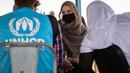 Aktris Angelina Jolie, utusan khusus PBB untuk UNHCR, berbincang dengan pengungsi Mali di kamp Goudebou, utara Burkina Faso, 20 Juni 2021. Jolie mengunjungi kamp itu sebagai bagian dari perannya sebagai duta organisasi pengungsi Perserikatan Bangsa-Bangsa (PBB), UNHCR. (OLYMPIA DE MAISMONT/AFP)