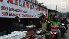 Warga menerima pembagian nasi bungkus gratis di Posko Perjuangan Rakyat (POSPERA), Jakarta, Rabu (10/3/2021). Pembagian 500 nasi bungkus beserta masker dan vitamin secara gratis setiap harinya dalam bentuk meringankan beban warga di tengah pandemi Covid-19. (merdeka.com/Imam Buhori)
