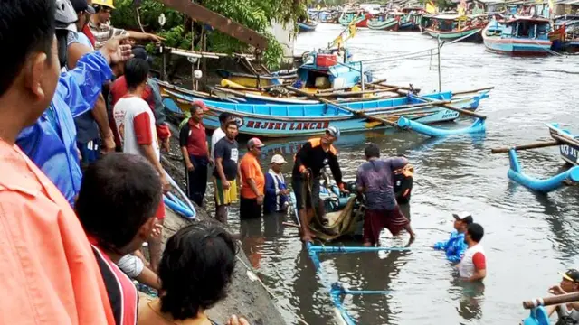 Nelayan bergotong royong mengevakuasi kapal yang tenggelam. (Foto: Liputan6.com/HNSI/Muhamad Ridlo).
