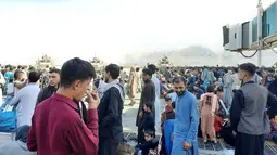 Warga Afghanistan berkerumun di landasan bandara Kabul pada 16 Agustus 2021, untuk melarikan diri dari negara itu ketika Taliban menguasai Afghanistan setelah Presiden Ashraf Ghani melarikan diri dan mengakui pemberontak telah memenangkan perang 20 tahun. (AFP Photo)