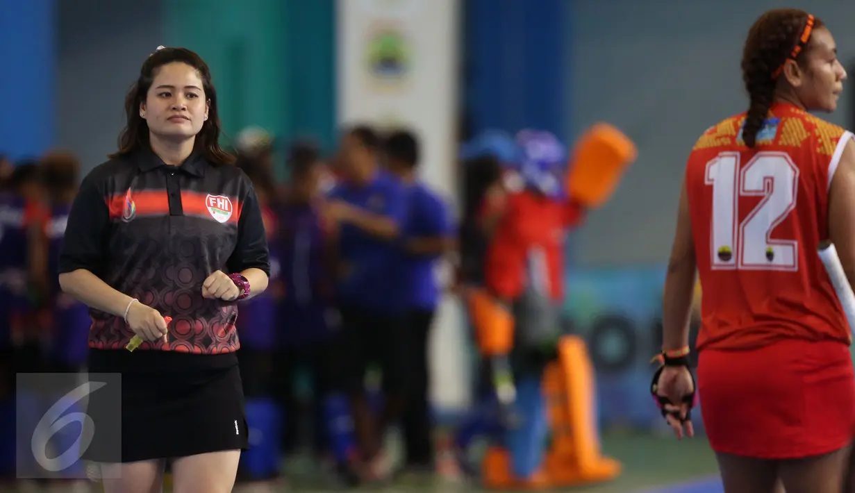 Wasit Ornpimol Kittiteerasopon (kiri) saat memimpin laga final hoki putri PON XIX Jabar antara DKI Jakarta melawan Papua di Gymnasium UPI, Bandung, Senin (19/9). DKI Jakarta unggul 4-2 atas Papua. (Liputan6.com/Helmi Fithriansyah)