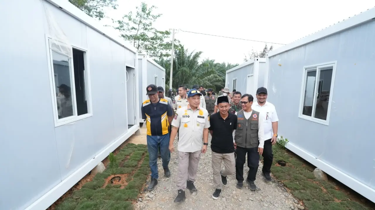 Menteri Dalam Negeri Tito Karnavian bersama warga meninjau hunian sementara