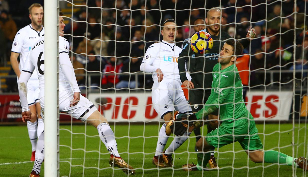 Gelandang Manchester City, David Silva, mencetak gol ke gawang Swansea City pada laga Premier League di Stadion Liberty, Rabu (13/12/2017). Manchester City menang 4-0 atas Swansea City. (AFP/Geoff Caddick)