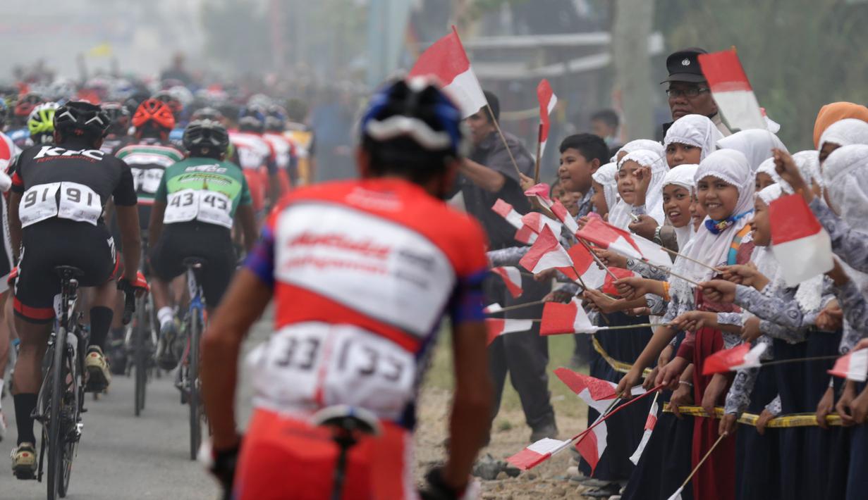 Sambutan warga setempat kepada para pebalap Etape 5 Tour de Singkarak 2015, Rabu (7/10/2015). (Bola.com/Arief Bagus)