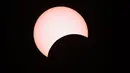 Bulan menutupi sebagian matahari selama gerhana matahari cincin (Annular Solar Eclipse) yang terlihat dari Mandalay di Myanmar, Minggu (21/6/2020). Sebagian penduduk Bumi bisa menyaksikan fenomena langka, Gerhana Matahari Cincin. (Ye Aung THU / AFP)