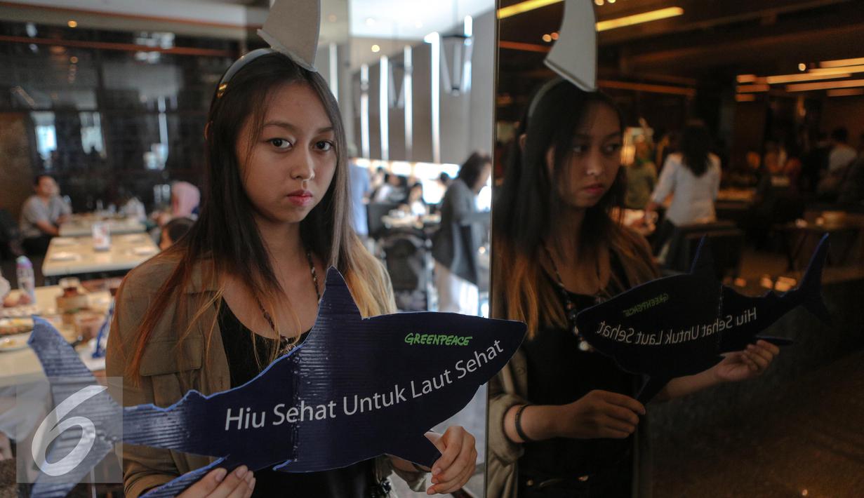 Aktivis Greenpeace Indonesia memperlihatkan replika hiu bertuliskan "Hiu Sehat untuk Laut Sehat" saat menggelar kampanye, Jakarta, Minggu (12/7/2015). Aksi tersebut sebagai upaya menyelamatkan hiu dari kepunahan. (Liputan6.com/Faizal Fanani)