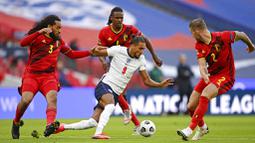 Striker Inggris, Dominic Calvert-Lewin, berusaha melewati pemain Belgia pada laga UEFA Nations League di Stadion Wembley, Minggu (11/10/2020). Inggris menang dengan skor 2-1. (Michael Regan/Pool via AP)