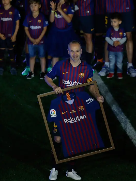Andres Iniesta memegang jersey Barcelona pada momen perpisahan usai laga penutup La Liga Spanyol melawan Real Sociedad di Stadion Camp Nou, Minggu (20/5). Iniesta resmi meninggalkan Barcelona setelah 22 tahun berkarier di sana (AFP/LLUIS GENE)