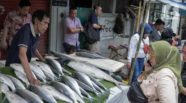 Pedagang ikan bandeng melayani pembeli di kawasan Rawa Belong, Jakarta, Selasa (21/1/2020). Bandeng yang biasanya menjadi hidangan khas saat Tahun Baru Imlek tersebut mulai ramai diperdagangkan di Rawa Belong. (Liputan.com/Faizal Fanani)