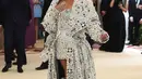 Penyanyi Rihanna menghadiri pagelaran Met Gala 2018 di Museum Seni Metropolitan New York, Senin (7/5). Rihanna mengenakan gaun pendek strapless yang seksi dilengkapi jubah berukirkan kristal dan mutiara. (Evan Agostini/Invision/AP)