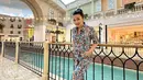 Melihat gaya liburan keren Fitri Carlina di Doha. Ia mengenakan jumpsuit bercorak ramai lengan pendek, dipadu sneakers putih, dan menyelipkan sunglasses di atas kepalanya. [Foto: Instagram/fitricarlina]