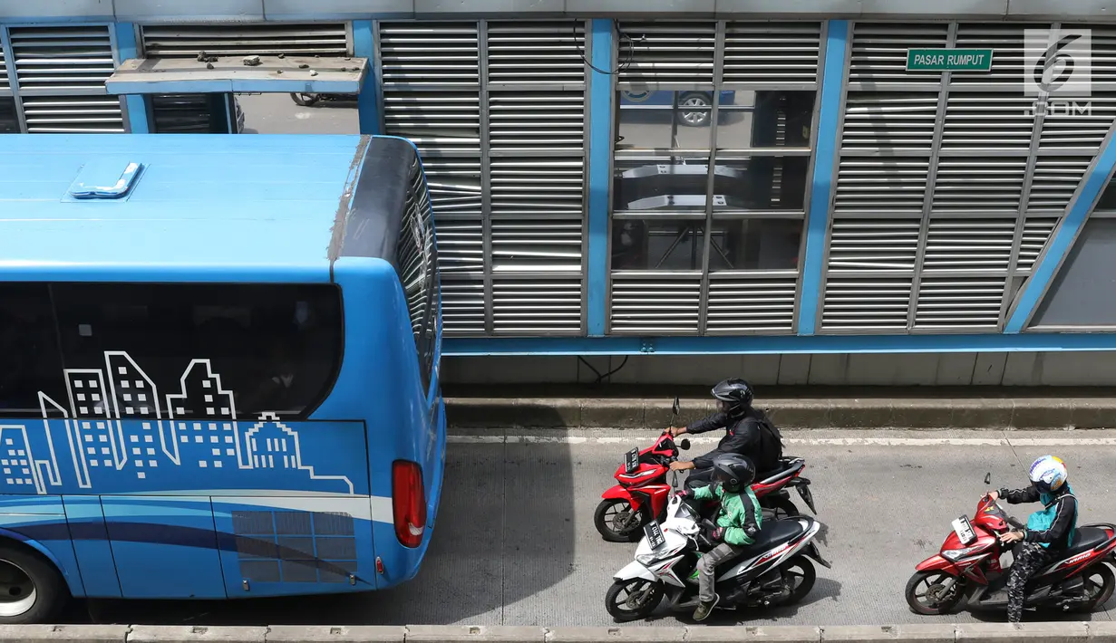 Pengendara motor melaju di belakang bus Transjakarta di kawasan Pasar Rumput, Jakarta, Rabu (20/2). PT Transportasi Jakarta akan memasang kamera pengawas (CCTV) di setiap halte untuk menerapkan tilang online atau E-Tilang. (Liputan6.com/Immanuel Antonius)