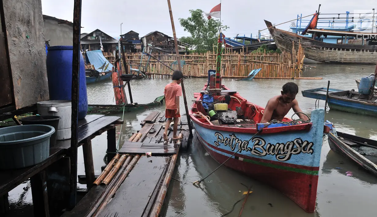 Nelayan beraktivitas saat banjir rob menggenangi permukiman Muara Angke, Jakarta, Selasa (22/1). Banjir air laut pasang atau Rob yang kembali melanda kawasan itu sejak 6 hari lalu membuat aktivitas warga sekitar terganggu. (Merdeka.com/Iqbal S. Nugroho)