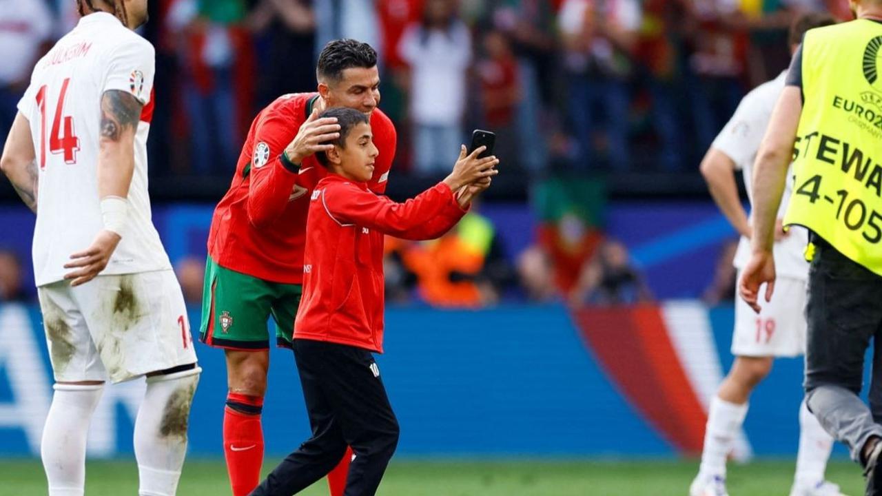 Aksi suporter cilik ketika mendapat rangkulan hangat oleh Ronaldo yang mau dengan sukarela berfoto dengannya. Foto: Reuters<br>