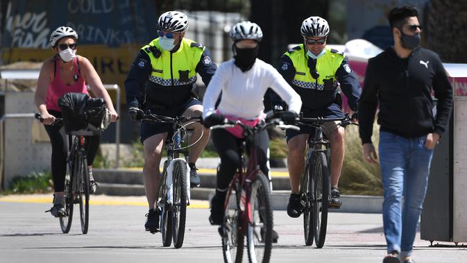 Polisi berpatroli dengan sepeda di sepanjang St Kilda Esplanade di Melbourne (26/10/2020). Pejabat kesehatan Australia melaporkan tidak ada kasus virus corona baru atau kematian di negara bagian Victoria. (AFP Photo/William West)