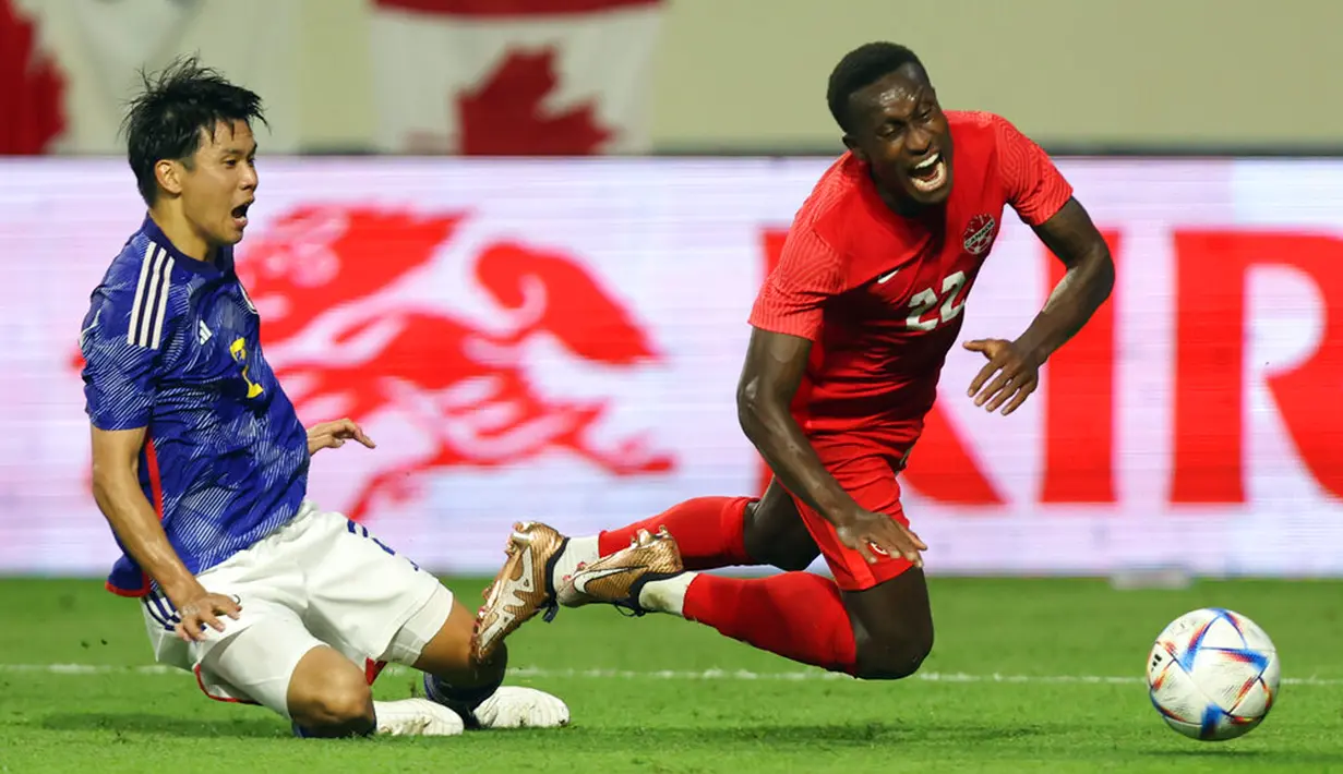Pemain Jepang Miki Yamane melanggar pemain Kanada Richie Laryea dalam kotak penalti pada pertandingan persahabatan di Dubai, 17 November 2022. Kanada mengalahkan Jepang dengan skor 2-1. (AP Photo/Christopher Pike)