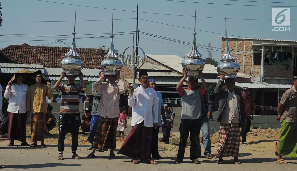 Warga membawa kubah saat pembongkaran Masjid Baitul Mustaghfirin yang berada di tengah tol fungsional Batang-Semarang, Jumat (28/9). Proses pembongkaran disaksikan ratusan warga setempat. (Liputan6.com/Gholib)