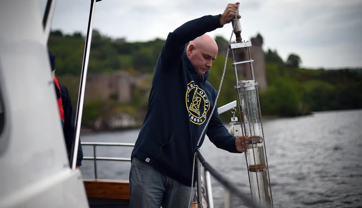Ahli genetika Universitas Otago Profesor Neil Gemmell mengambil sampel air dari perairan Loch Ness, Drumnadrochit, Skotlandia, 11 Juni 2018. Tim dari Selandia Baru menguji kebenaran dari keberadaan moster raksasa Loch Ness. (Andy Buchanan/AFP)