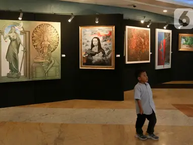 Seorang anak berdiri dekat karya yang dipajang pada pameran seni rupa di Plaza Teater Besar, Taman Ismail Marzuki, Jakarta, Selasa (21/5/2024). (Liputan6.com/Herman Zakharia)