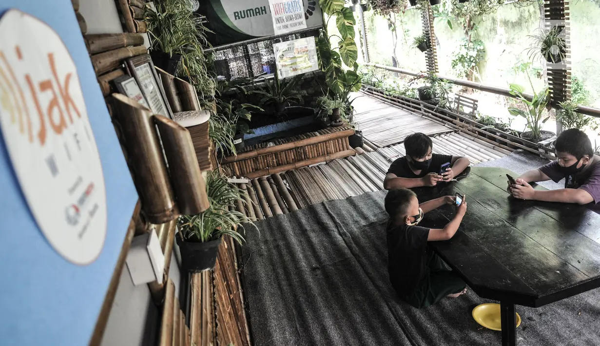Sejumlah siswa menggunakan jaringan JakWiFi saat mengikuti kegiatan PJJ di Rumah Diskusi RT 007/008 Cipinang Besar Utara, Jakarta, Selasa (8/9/2020). Pemerintah Provinsi DKI Jakarta menargetkan untuk memasang lebih dari 9.000 titik internet gratis di ruang publik. (merdeka.com/Iqbal S. Nugroho)