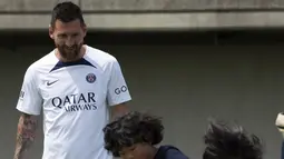 Pemain sepak bola Paris Saint-Germain (PSG) Lionel Messi melihat anak-anak bermain sepak bola saat melakukan pelatihan di Tokyo, Jepang, 18 Juli 2022. PSG berada di Jepang untuk tur pra-musim mereka dan akan memainkan tiga pertandingan persahabatan melawan tim Liga Jepang. (AP Photo/Eugene Hoshiko)