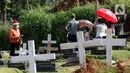 Warga melakukan ziarah di area pemakaman khusus dengan protokol COVID-19 di TPU Pondok Ranggon, Jakarta, Jumat (25/12/2020). Momen perayaan Natal 2020 dimanfaatkan sejumlah umat kristiani untuk berziarah mendoakan kerabat yang dimakamkan dengan protokol COVID-19. (Liputan6.com/Helmi Fithriansyah)
