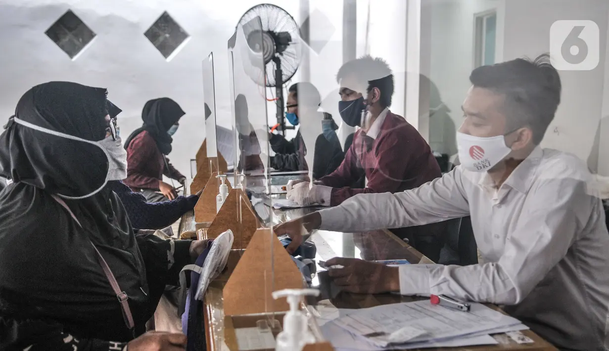 Petugas melayani Orangtua dari anak penerima KJP kawasan Matraman, Jakarta, Selasa (24/11/2020). Penyaluran KJP dibagi per wilayah dan per jenjang pendidikan yang akan berlangsung selama seminggu. (merdeka.com/Iqbal S. Nugroho)