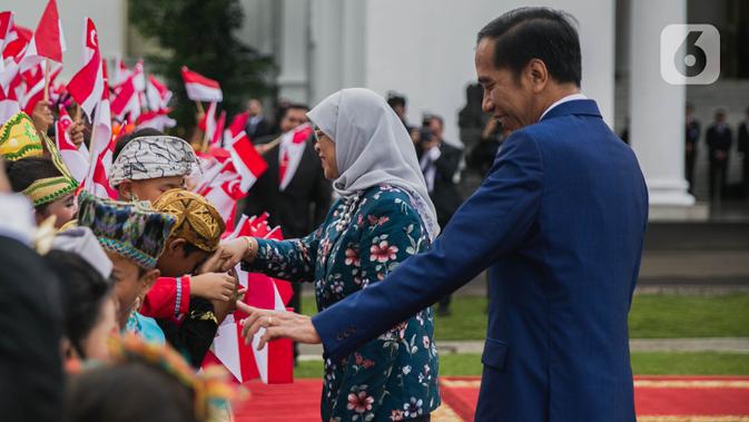 Presiden Joko Widodo (kanan) bersama Presiden Singapura, Halimah Yacob menyapa anak-anak berbaju daerah saat penyambutan kenegaraan di Istana Bogor, Jawa Barat, Selasa (4/3/2020). Halimah datang ke Indonesia bersama suaminya Mohamed Abdullah Alhabshee. (Liputan6.com/Faizal Fanani)
