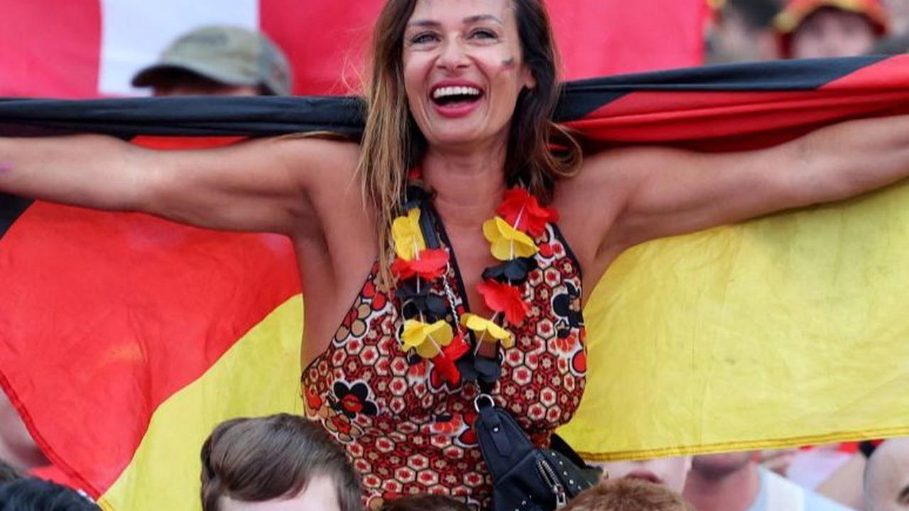 Suporter cantik Jerman membentangkan bendera saat mendukung langsung Tim Panser.&nbsp;Foto: AFP
