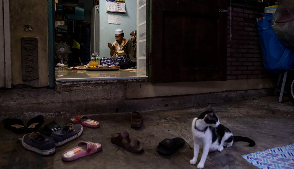 Sebuah keluarga Muslim Thailand berdoa sebelum berbuka puasa di ruang tamu rumah mereka di Bangkok, pada 28 April 2020. Banyak tempat ibadah ditutup guna membendung penyebaran Virus Corona COVID-19 ketika Umat Muslim di seluruh dunia menyambut bulan suci Ramadan. (AP Photo/Gemunu Amarasinghe)