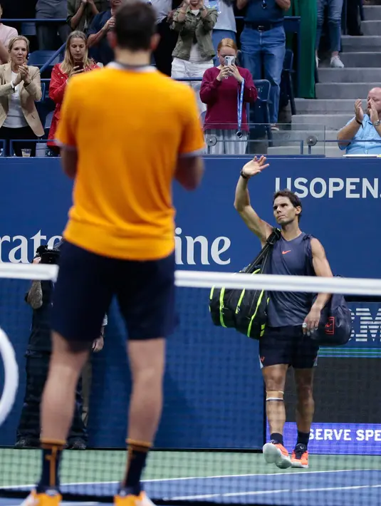 Petenis Spanyol, Rafael Nadal meninggalkan lapangan usai mengundurkan diri saat melawan Juan Martin del Potro dari Argentina pada semifinal AS Terbuka 2018, Jumat (7/9).Nadal tak mampu melanjutkan pertandingan disebabkan cedera lutut. (AP/Andres Kudacki)