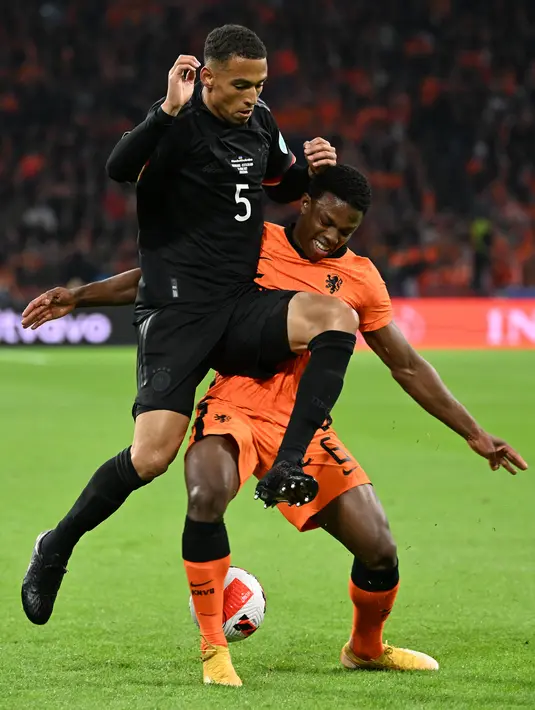 <p>Bek Belanda, Tyrell Malacia (kanan) berebut bola dengan bek Jerman, Thilo Kehrer saat pertandingan persahabatan di Johan Cruyff ArenA di Amsterdam pada 29 Maret 2022. Malacia diboyong dengan banderol 15 juta euro (Rp 232 miliar) dengan biaya tambahan 2 juta euro. (AFP/Ina Fassbender)</p>