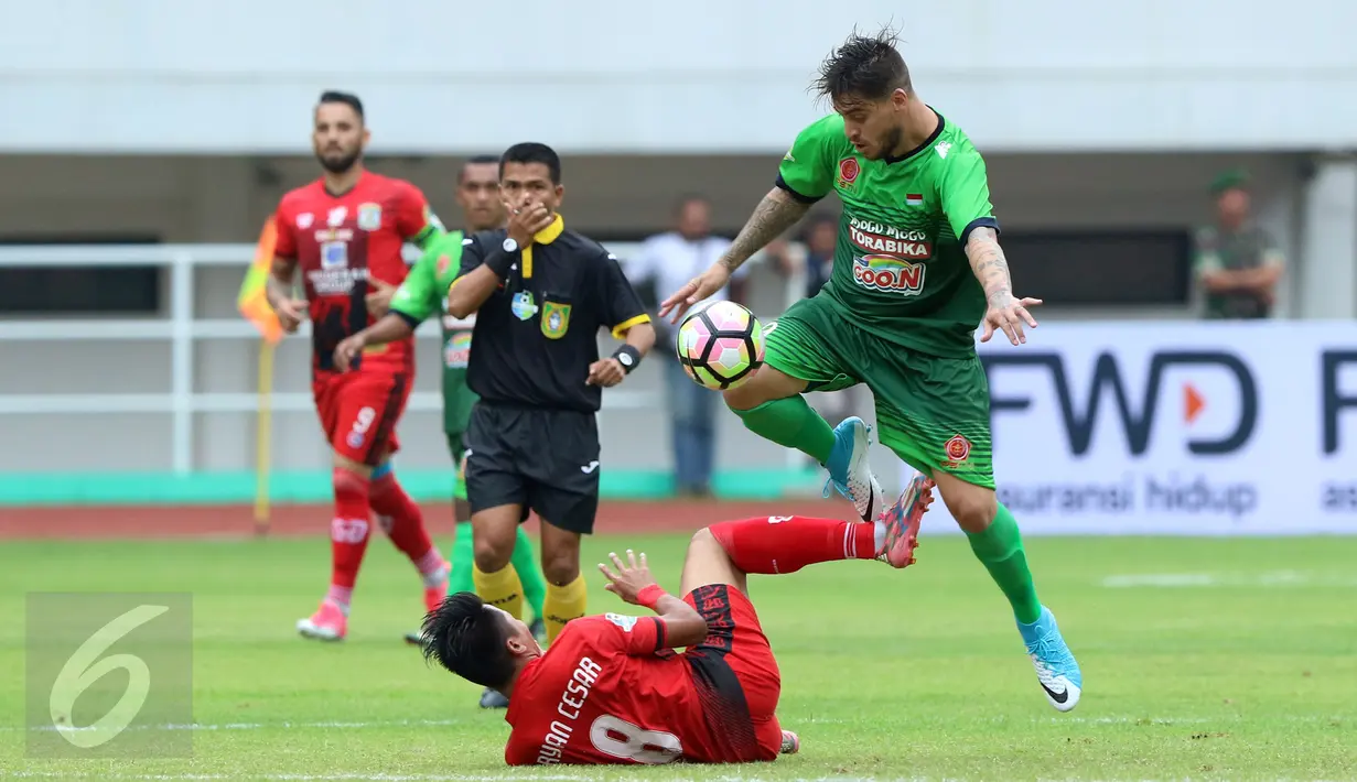 Penyerang PS TNI, Lionel Jorge Nunez (kanan) menghindari tekel pemain Persiba Bryan Cesar Ramadhan pada laga lanjutan Liga 1 Indonesia di Stadion Pakansari, Kab Bogor, Jumat (5/5). Laga kedua tim berakhir imbang 1-1. (Liputan6.com/Helmi Fithriansyah)
