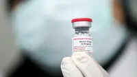 Pekerja laboratorium menunjukkan botol vaksin Sinovac di laboratorium Vacsera, Kairo, Mesir, Rabu (1/9/2021). Laboratorium Vacsera di Mesir membuat vaksin Sinovac China untuk mencegah penularan virus corona. (AFP/Khaled Desouki)