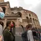 Orang-orang memakai masker untuk mencegah penyebaran COVID-19 saat mereka berjalan-jalan di dekat Colosseum, di Roma pada Sabtu (3/10/2020). Masker wajah harus dipakai setiap saat di luar rumah di ibu kota Italia Roma dan wilayah sekitar Lazio mulai Sabtu, 3 Oktober. (AP Photo/Andrew Medichini)