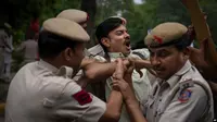 Ilustrasi yang menunjukkan polisi menangkap seorang mahasiswa yang ikut serta dalam aksi protes di New Delhi, India. . (Foto: AP/Altaf Qadri)