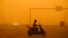 Seorang pengendara mengendarai skuter saat badai debu berat menghantam Baghdad, Irak, Senin (16/5/2022). (Sabah ARAR/AFP)