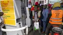 Seorang pria pergi dengan wadah setelah antre mengisi bahan bakar yang masih tersedia di salah satu pompa bensin di Hurlingham, Nairobi, 14 April 2022. Selama berminggu-minggu Kenya menderita kekurangan di pompa bensin dengan ada yang tidak memiliki bahan bakar sama sekali (AP Photo/Khalil Senosi)