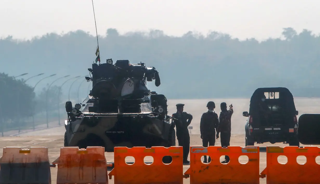 Tentara Myanmar berjaga di penghalang jalan yang diawaki dengan kendaraan lapis baja di jalan menuju gedung parlemen di Naypyitaw, Myanmar, Selasa (2/2/2021). Militer Myanmar menahan pemimpin yang terpilih secara demokratis Aung San Suu Kyi dan memberlakukan keadaan darurat satu tahun. (AP Photo)
