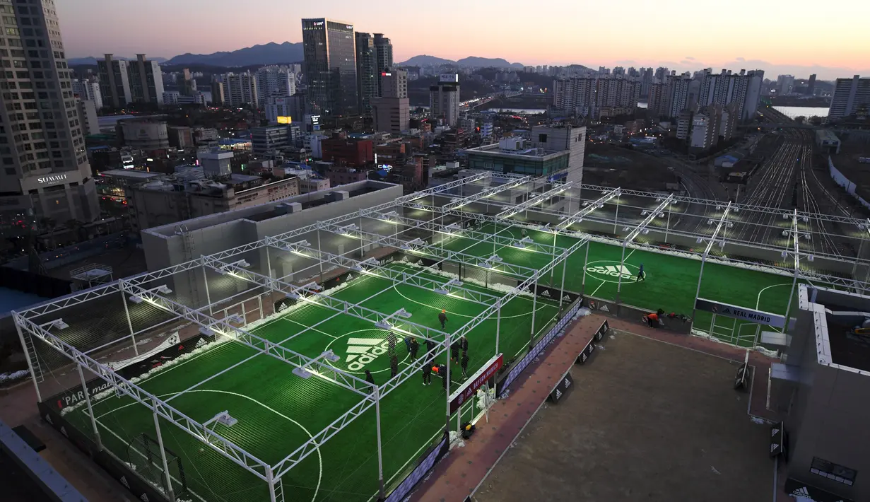 Penampakan lapangan sepak bola yang berada di atap sebuah pusat perbelanjaan di Seoul, Korea Selatan, 16 Desember 2017. Pemadangan indah gedung-gedung pencakar langit Kota Seoul membuat olahraga Anda semakin terasa berkesan. (JUNG Yeon-Je/AFP)