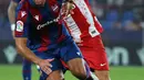 Bek Levante, Rober Pier (kiri) membawa bola dari kejaran gelandang Atletico Madrid, Joao Felix selama pertandingan La Liga Spanyol di stadion Ciutat de Valencia di Valencia (29/10/2021). Atletico kini menempati di urutan keenam klasemen sementara LaLiga dengan 19 poin. (AFP/Jose Jordan)